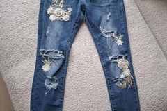 Parduoda: Plėšyti siaurėjantys džinsai su aplikacijomis